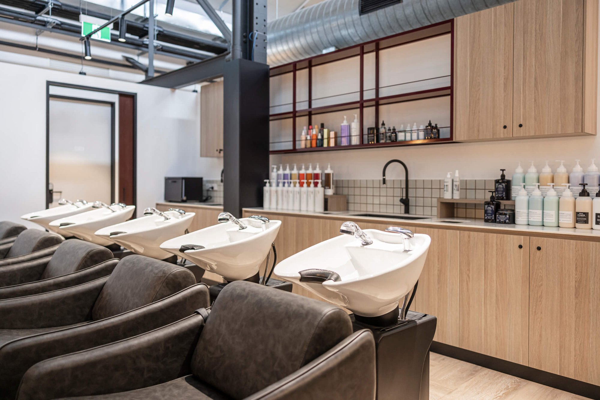 Hair washing basins and chairs with hair care products in Salon Lane West End